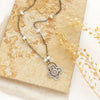 The Layered Talara Pearl Necklace styled on a tan rock with linen and dried grass