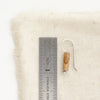 A picture jasper lobe hugger earring next to a ruler for size reference.