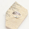 The stamped silver feather stacking ring is styled on an organic stone