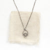 The mini talara shield necklace styled on tan linen