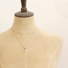 A mannequin wearing the pearl and ruby gold necklace