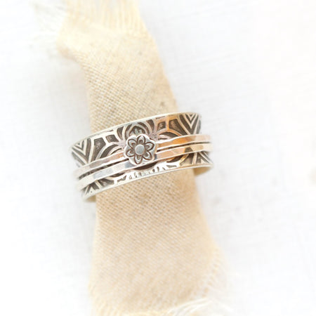 The flower spinner ring styled on tan linen