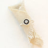 The clover stacking ring styled on rolled tan linen