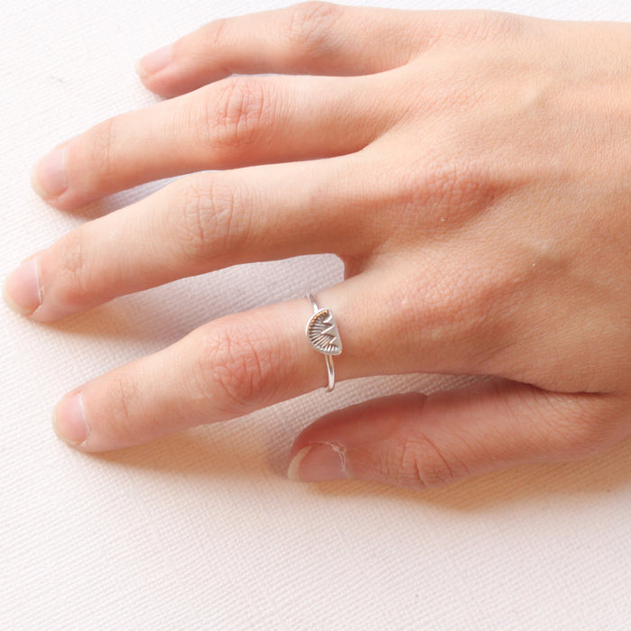A hand wearing the alpine glow tacking ring