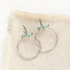 The amazonite halp hoop earrings styled on tan linen