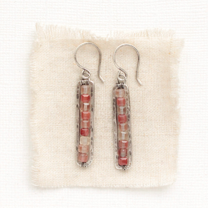 The andesine beaded bar earrings styled on tan linen