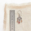 A mini talara andesine earring next to a ruler for size reference