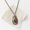 The apache gold necklace styled on tan linen