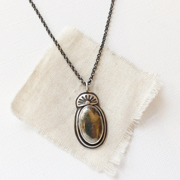 The apache gold necklace styled on tan linen