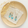 The apatite and turquoise necklace styled on a tan plate with the matching earrings