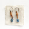 The aquamarine leather earrings styled on tan linen