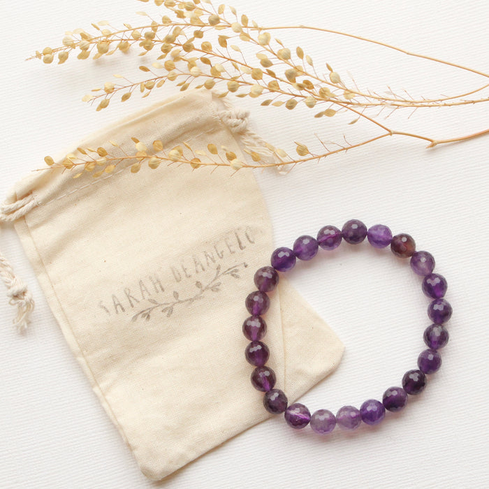 The beaded amethyst stretch bracelet styled with the branded canvas bad and dried grass