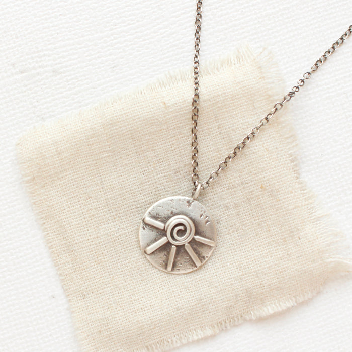 The big musana necklace styled on tan linen