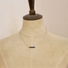 A mannequin wearing the black ethiopian bar necklace
