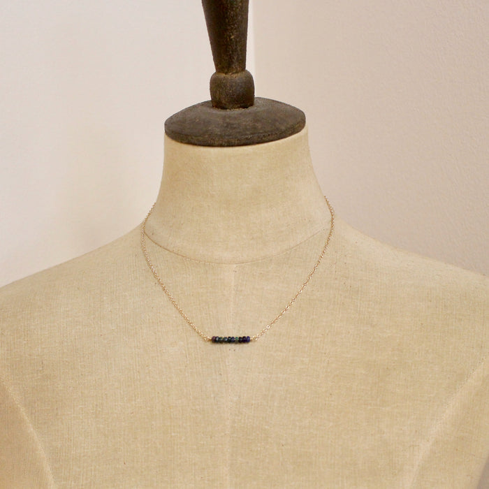 A mannequin wearing the black ethiopian bar necklace