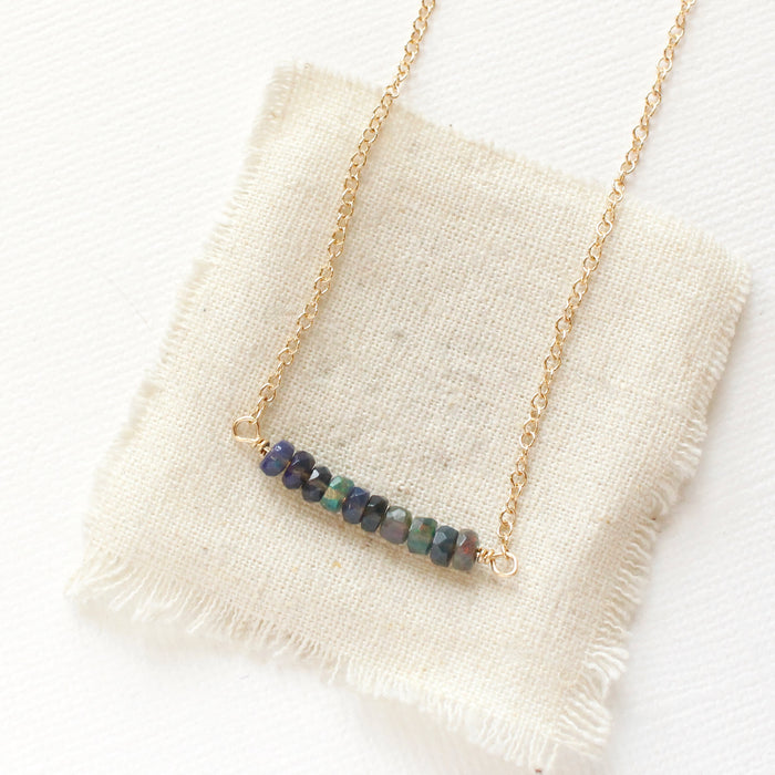 The black ethiopian opal bar necklace styled on tan linen