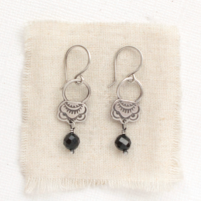 The black tourmaline jolie earrings styled on tan linen