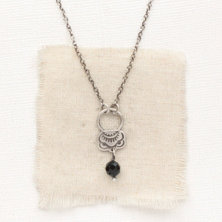 The black tourmaline jolie necklace styled on tan linen