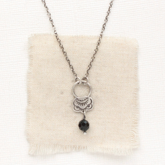The black tourmaline jolie necklace styled on tan linen