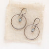 The zircon silver hoop earrings styled on tan linen