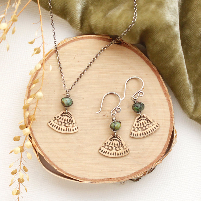 The bronze asmi triangle and african jasper earrings styled on wood with the matching necklace