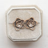 The bronze layered cactus flower post earrings styled on a white velvet box