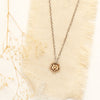 The bronze mini cactus flower necklace styled on linen with dried grass