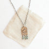 The bronze wanderer arch green apatite necklace styled on tan linen