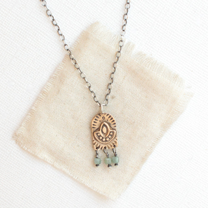 The bronze wanderer arch green apatite necklace styled on tan linen