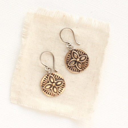 The bronze wanderer coin earrings styled on tan linen