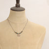 A mannequin wearing the bronze wanderer coin lona necklace