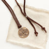 The bronze wanderer medallion leather necklace styled on tan linen