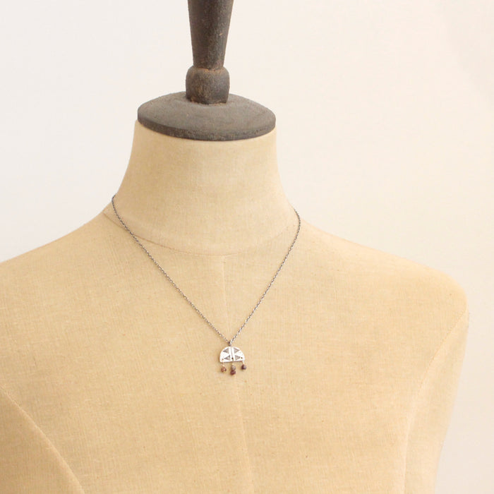 A mannequin wearing the brown zircon mixed metal pakal arch necklace