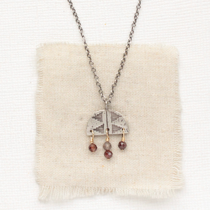The brown zircon mixed metal pakal arch necklace styled on tan linen