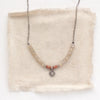 The talara sun zaria necklace styled on tan linen