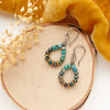 The chrysocolla stone hoop earrings styled on wood with velvet and dried grass