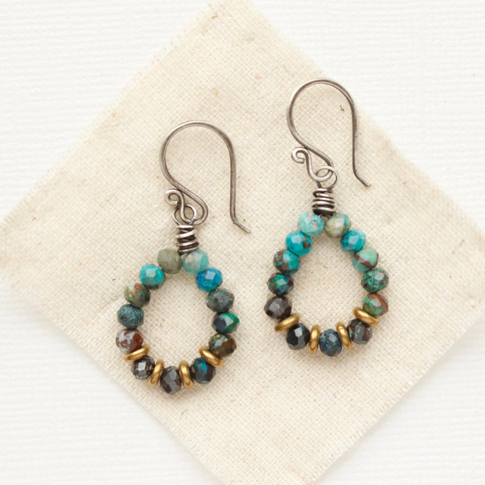 The chrysocolla hoop earrings styled on tan linen