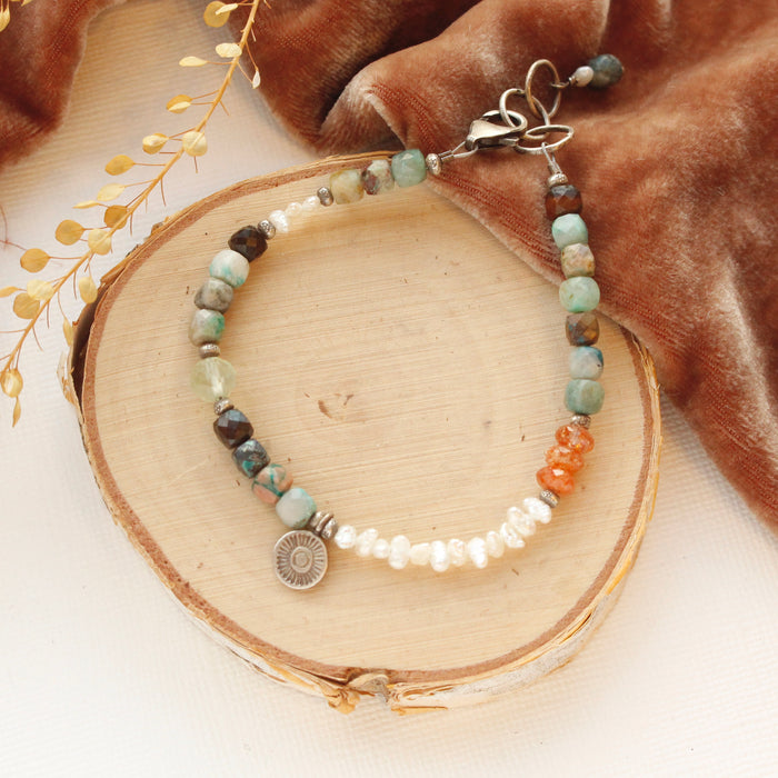 The talara sun mesa bracelet styled on wood with orange velvet and dried grass