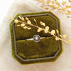 The columbine burst stacking ring styled on a green velvet box with linen and dried grass
