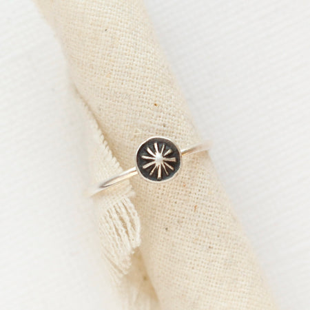 The columbine burst stacking ring styled on a piece of rolled linen