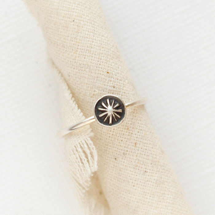 The columbine burst stacking ring styled on a piece of rolled linen