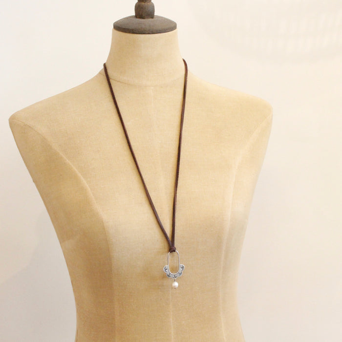 A mannequin wearing the columbine hoop pearl adjustable leather necklace in the long style