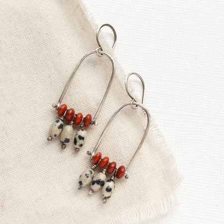 The moab arch earrings styled on tan linen