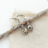 The perfect wrapped dalmatian jasper earrings styled on tan linen with a wooden stick