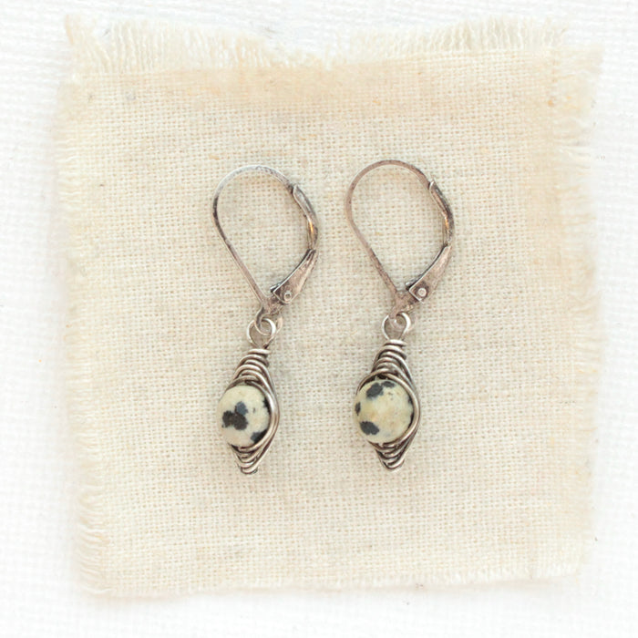 The perfect wrap dalmtian jasper earrings styled on tan linen