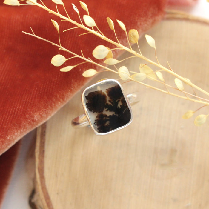 The dendritic agate ring styled on wood with orange velvet and dried grass