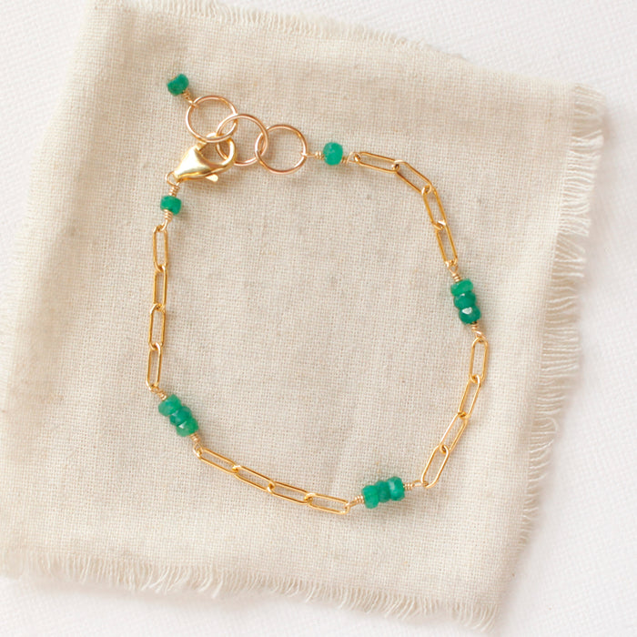The emerald paperclip bracelet styled on tan linen