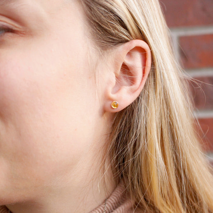 The citrine post earrings being worn in an ear