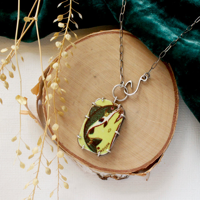 The fish tales vintage plate necklace styled on wood with green velvet and dried grass
