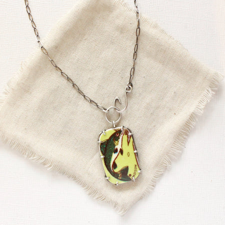 The fish tales vintage plate necklace styled on tan linen